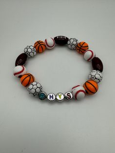 Show off your love for sports with our custom-made Sports Beads Bracelet! Perfert for athletes, sports enthusiasts, or anyone who loves to show team spirit. Each bracelet is handcrafted with high-quality beads representing your favorite sport(s). Whether you love baseball, football, soccer, or a mix of all three, we've got you covered! Casual Beaded Bracelets In Team Colors For Sports Events, White Team Spirit Wristbands For Team Events, White Team Spirit Wristband For Team Events, Casual Round Beads Bracelets For Sports Events, Casual White Bracelets For Team Events, Personalized Beaded Bracelets For Team Events, White Team Spirit Bracelets For Game Day, Sporty White Beaded Bracelets For Team Events, White Beaded Bracelets For Sports Events