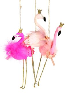 three pink and gold flamingos are hanging from strings with crowns on their heads, one is wearing a tiara