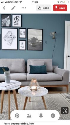 a living room with blue walls and pictures on the wall above it's coffee table