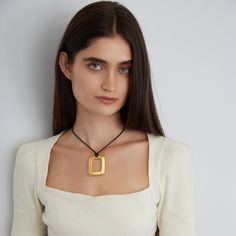 Elevate your jewelry collection with the Encanto necklace, showcasing a sophisticated square design. Handcrafted with 24K gold-plated metal alloy on a waxed cotton cord, it features an adjustable fastener that allows you to shorten or lengthen the necklace for your desired neckline. All jewelry is handcrafted and made to order in our New York City design studio. Please allow 7-14 business days for production from the order date. Measurements: 36" in length with a 2" L x 1 1/2" W pendant Formal Necklace, Beachy Necklace, Dainty Choker, Necklaces Silver, Square Pendant, Handcrafted Necklace, City Design, Classic Gold, Spring Trends