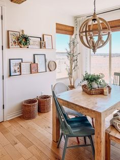 a dining room table with two chairs and a bench in front of a large window