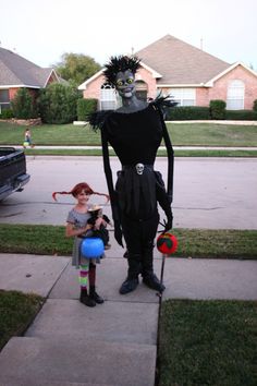 two people dressed up in costumes standing on the sidewalk