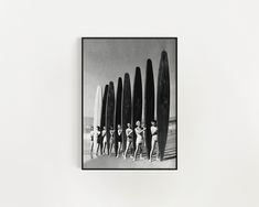 a group of men standing next to surfboards on top of a white wall in front of them