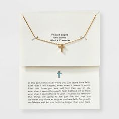 a card with a cross on it next to a necklace