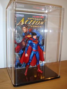 a superman action figure in a clear case