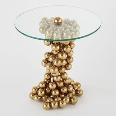 a glass table topped with lots of gold balls