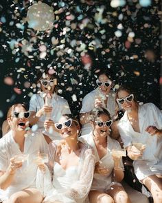 a group of people sitting on top of a wooden floor covered in confetti