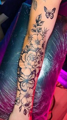 a woman's leg with flowers and butterflies on it