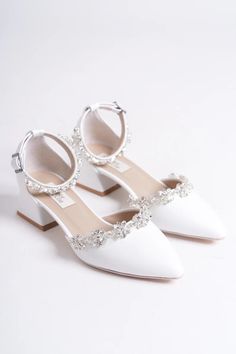 a pair of white shoes with jeweled straps