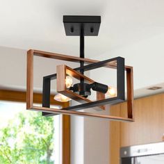 a light fixture in a kitchen with wood and metal fixtures hanging from it's ceiling