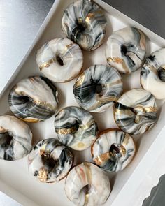 a box filled with donuts covered in white and black glazed icing