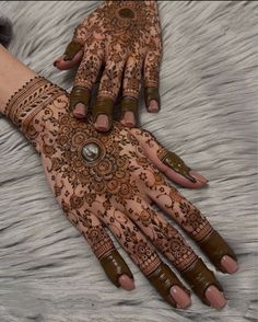 two hands with henna tattoos on them