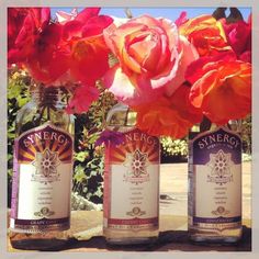 three bottles with flowers in them sitting on a table