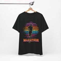 Introducing the Marathon T-Shirt, a perfect blend of comfort, style, and motivation for all the dedicated runners who conquer the roads. Available with express delivery in navy, black and dark grey heather, this runner t-shirt features a bold and inspiring design, a silhouetted runner against a striped colored sunset background with a shirt that proudly displays "Marathon", a graphic that symbolizes the relentless spirit of marathon runners. The vibrant colors and sharp details of the print make Sporty Running T-shirt With Letter Print, Sporty Graphic Print T-shirt For Marathon, Athletic Fit Graphic Print T-shirt For Sports Season, Sporty Running T-shirt With Logo Print, Sporty Letter Print T-shirt For Running, Short Sleeve Running T-shirt With Logo Print, Casual Running T-shirt With Logo Print, Graphic Crew Neck T-shirt For Running, Sporty Pre-shrunk T-shirt For Marathon