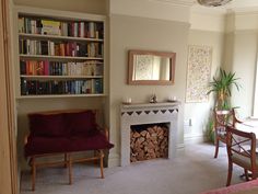 a living room filled with furniture and a fire place next to a book shelf full of books