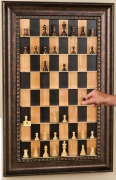 a man standing next to a framed chess board