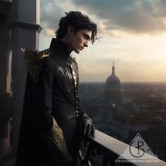 a man dressed in black standing on top of a balcony next to a cityscape