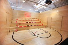 an indoor basketball court with several rows of shoes on the shelves