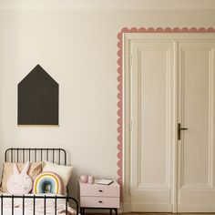 a bedroom with white walls and pink accents