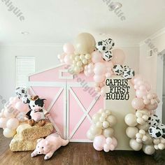 this is an image of a cow themed party with balloons and farm animals on the wall