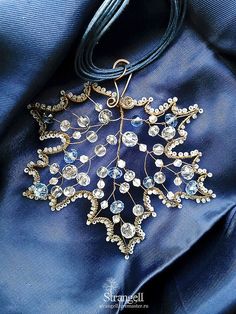 a brooch that is on top of a blue piece of cloth and some beads