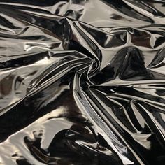 an abstract black and white photograph of shiny metal material, with some folds in the middle