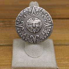 This stunning sterling silver ring features an intricate Aztec calendar design. The detailed craftsmanship and symbolic imagery make it a unique and meaningful piece. The face of the ring measures 1 13/16" in diameter. The split double shank measures 5mm thick. The ring weighs 26.5g and is a size 7.75. We can size most rings for an additional fee, please message me with what size you need and I will get back to you with a price. There is no artist's hallmark on the ring but (STERLING) is stamped Adjustable Engraved Antique Silver Ring, Antique Silver Engraved Ring Collectible, Collectible Antique Silver Engraved Ring, Symbolic Antique Silver Engraved Ring 925, Symbolic Nickel-free Engraved Ring, Aztec Sun God, Aztec Sun, Aztec Calendar, Sun God