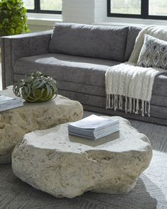 a living room filled with furniture and a stone coffee table in front of a couch