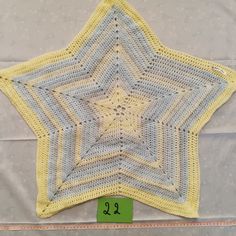 a crocheted yellow and gray star with numbers on it