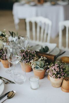 the table is set with flowers and wine glasses