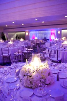 the tables are set with white flowers and place settings