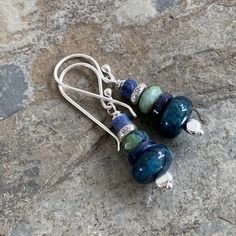 These earrings are handmade and stacked with neon apatite, lapis lazuli, chrysocolla and sterling Hill Tribe silver. Each bead complements the next in these multi gem earrings. Ear wires, headpins and accent beads are all sterling silver. * Total length including ear wire: 1.5 inch * Neon apatite Rondelle: 10mm Your jewelry will arrive in a cotton lined kraft box within a padded postal envelope. I use USPS first class mail. This usually takes 3 to 5 days to ship. International orders outside of Blue Sterling Silver Earrings With Gemstone Beads, Stack Earrings, Pyrite Earrings, Stacked Earrings, Gem Earrings, Labradorite Bracelet, Hill Tribe Silver, Bride And Groom Gifts, Earrings Ear