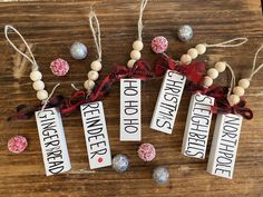 four wooden tags with words on them hanging from string and some other decorations around it