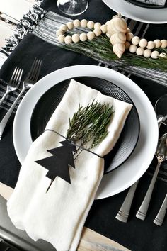 black and white place setting with pine cone napkins