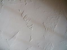 the wall is white and has peeling paint on it