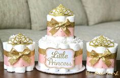 a pink and gold diaper cake sitting on top of a table