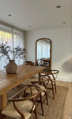 a dining room table with chairs and a vase on it