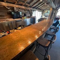 a long counter in a restaurant with chairs around it