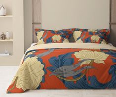 a bed with an orange and blue floral comforter