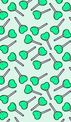 green lollipops with sticks in the shape of hearts on a blue background