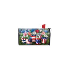 an american flag mailbox cover with flowers and patriotic flags on the front, in grass