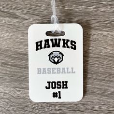 Show your Hawks Baseball pride with a personalized bag tag! Tags measure approximately 4" x 2.75" and include a clear strap to attach to a bag. Design is printed directly onto the tag on both sides. Tag is created from fiber reinforced plastic for long lasting use. Can be used on backpacks or luggage. White Rectangular Badge Holders For Everyday Use, Personalized Rectangular Luggage Tag For School, Customizable White Luggage Tag For Travel, Personalized White Rectangular Luggage Tag, Rectangular White Badge Holders As Gift, White Rectangular Badge Holder For Personal Use, Black Rectangular Luggage Tag For School, Customizable White Badge Holders For Personal Use, Customizable Rectangular Luggage Tag For Personal Use