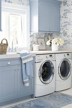 a washer and dryer in a blue laundry room with floral wallpaper on the walls