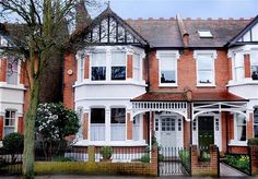 a large brick house with many windows and white trimmings on it's sides