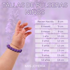 a baby's hand holding a purple beaded bracelet with numbers and times on it