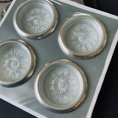 three silver plates sitting on top of a metal tray with sunburst designs in them