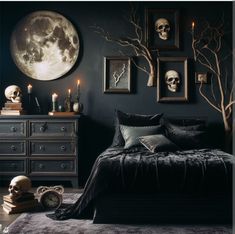 a bedroom decorated in black and white with skulls on the wall, candles and pictures