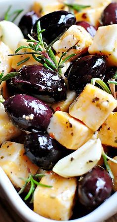 olives, potatoes and herbs in a white bowl on a wooden table with text overlay