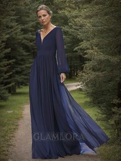 a woman in a long blue dress standing on a path