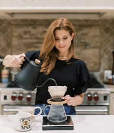 a woman pours coffee into a glass pitcher